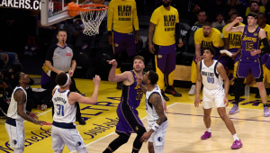 O armador do Los Angeles Lakers, Luka Dončić (C), arremessa a bola durante o primeiro tempo do jogo de basquete da NBA entre o Dallas Mavericks e o Los Angeles Lakers