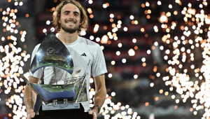 O grego Stefanos Tsitsipas posa com o troféu no pódio após vencer a final do ATP Dubai