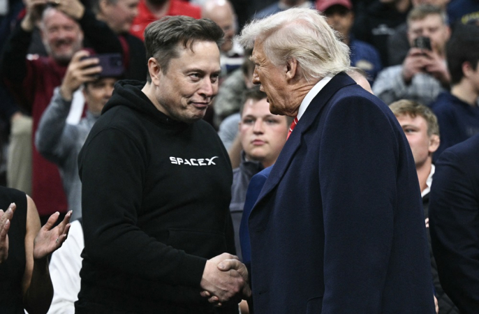 O CEO da Tesla e da SpaceX, Elon Musk, e o ex-presidente dos EUA, Donald Trump, apertam as mãos durante a competição masculina de wrestling da NCAA no Wells Fargo Center, na Filadélfia