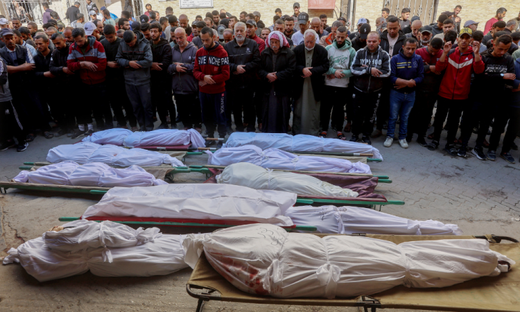 Palestinian mourners pray over the bodies of victims of overnight Israeli airstrikes on the Gaza Strip at Al-Ahli Arab hospital, also known as the Baptist hospital, in Gaza City ahead of their burial on March 18, 2025. Israel on March 18 unleashed its most intense strikes on the Gaza Strip since a January ceasefire, with rescuers reporting 220 people killed, and Hamas