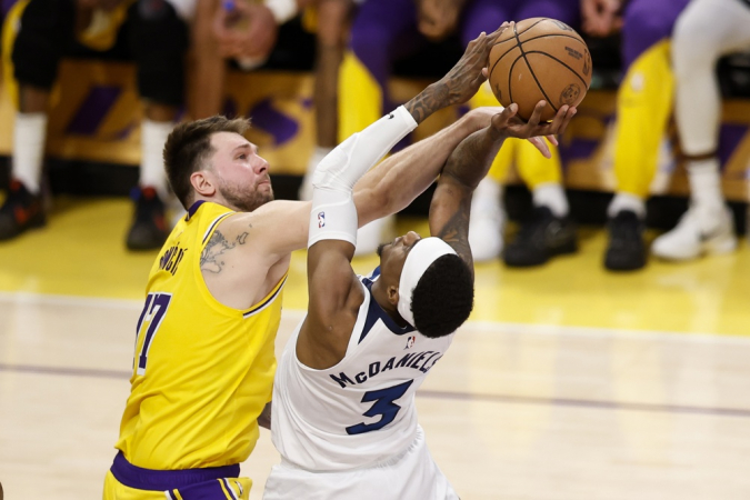 O armador do Los Angeles Lakers, Luka Doncic (à esq.), tenta bloquear o ala do Minnesota Timberwolves, Jaden McDaniels (à dir.)