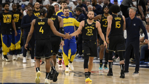 Stephen Curry (#30) e Moses Moody (#4), do Golden State Warriors, comemoram com um high five durante o jogo contra o Minnesota Timberwolves