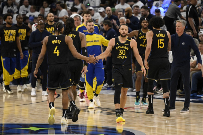 Stephen Curry (#30) e Moses Moody (#4), do Golden State Warriors, comemoram com um high five durante o jogo contra o Minnesota Timberwolves