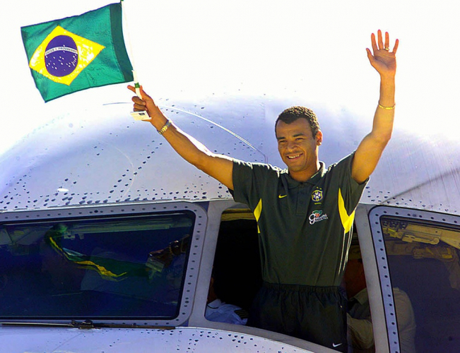 O capitão da Seleção Brasileira, Cafu, acena para os torcedores, segurando a bandeira do Brasil