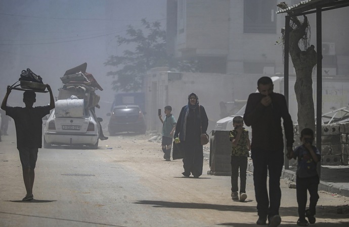 Palestinos deslocados internamente fogem da área com seus pertences após um ataque aéreo israelense a oeste da Cidade de Gaza