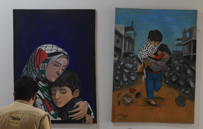 Um visitante observa obras de artistas iemenitas durante uma exposição de arte em solidariedade ao povo palestino, em Sana'a, no Iêmen