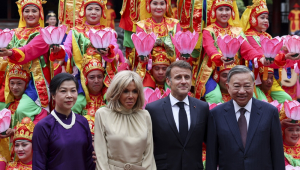 O secretário-geral do Partido Comunista do Vietnã, To Lam, e sua esposa, Ngo Phong Ly, junto com o presidente francês, Emmanuel Macron, e sua esposa, Brigitte Macron, posam para uma foto com dançarinos tradicionais durante um almoço no Van Mieu, em Hanói
