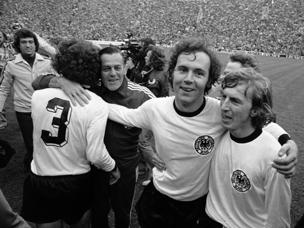 O jogador de futebol da Alemanha Ocidental, Franz Beckenbauer (2º à dir.), comemora com seu companheiro de time Juergen Grabowski (d), durante volta no Estádio Olímpico de Munique
