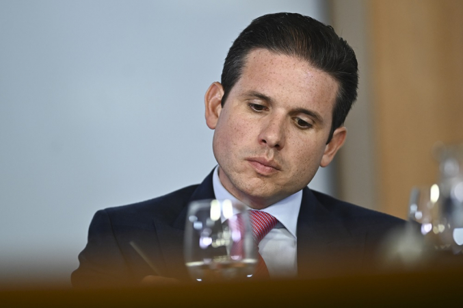 Hugo Motta aparentemente pensativo, sentado em frente a uma mesa no Palácio do Planalto