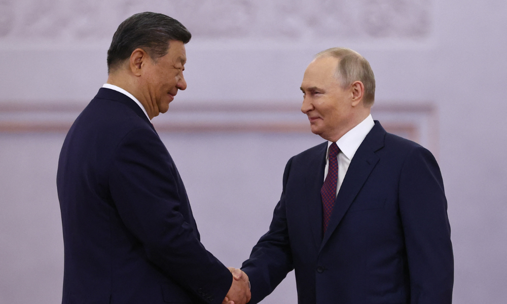 O presidente russo, Vladimir Putin, e seu homólogo chinês, Xi Jinping, apertam as mãos durante uma cerimônia de boas-vindas antes de suas conversas no Kremlin, em Moscou, em 8 de maio de 2025