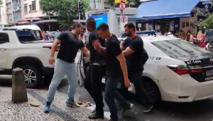 Agentes da Polícia Civil conduzem rão Rogério de Souza Batista à delegacia