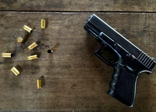 Balas vazias e uma arma na mesa