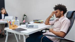 Homem cansado com laptop no trabalho