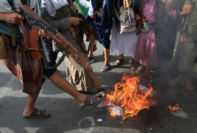 Apoiadores houthis queimam bandeiras dos Estados Unidos e de Israel durante protesto contra os bombardeios israelenses ao Irã