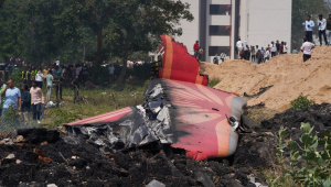 Pessoas observam os destroços no local de um acidente aéreo próximo ao Aeroporto Internacional Sardar Vallabhbhai Patel, em Ahmedabad