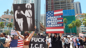 Pessoas participam de um protesto contra o presidente Donald Trump durante a mobilização nacional intitulada "No Kings" ("Reis Não"), realizada neste sábado ao lado da Antorcha da Amizade, no centro de Miami, Flórida