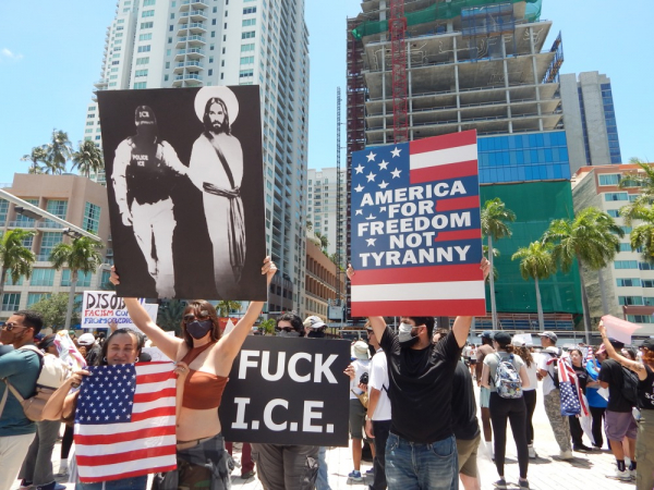Pessoas participam de um protesto contra o presidente Donald Trump durante a mobilização nacional intitulada "No Kings" ("Reis Não"), realizada neste sábado ao lado da Antorcha da Amizade, no centro de Miami, Flórida