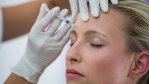 Paciente do sexo feminino recebendo uma injeção de botox na testa