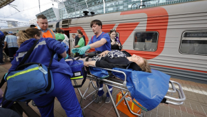 Socorristas russos atendem passageiros feridos após a chegada do trem na estação ferroviária de Kievsky, em Moscou