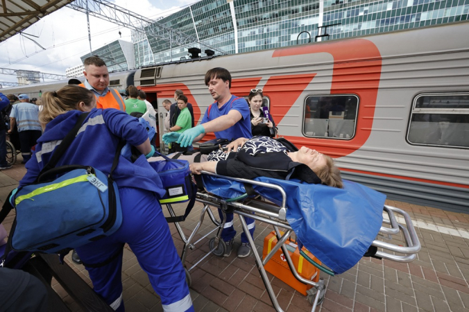 Socorristas russos atendem passageiros feridos após a chegada do trem na estação ferroviária de Kievsky, em Moscou