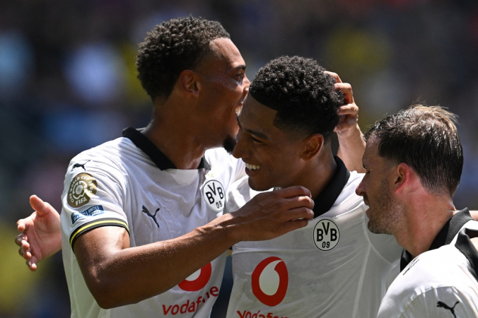 Jobe Bellingham, meio-campista inglês do Borussia Dortmund (#77), é cumprimentado pelos companheiros após marcar o terceiro gol da equipe