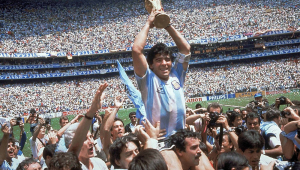 Com o troféu em mãos, Maradona é carregado pelos companheiros após conquistar a Copa com a Argentina