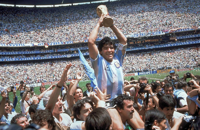 Com o troféu em mãos, Maradona é carregado pelos companheiros após conquistar a Copa com a Argentina