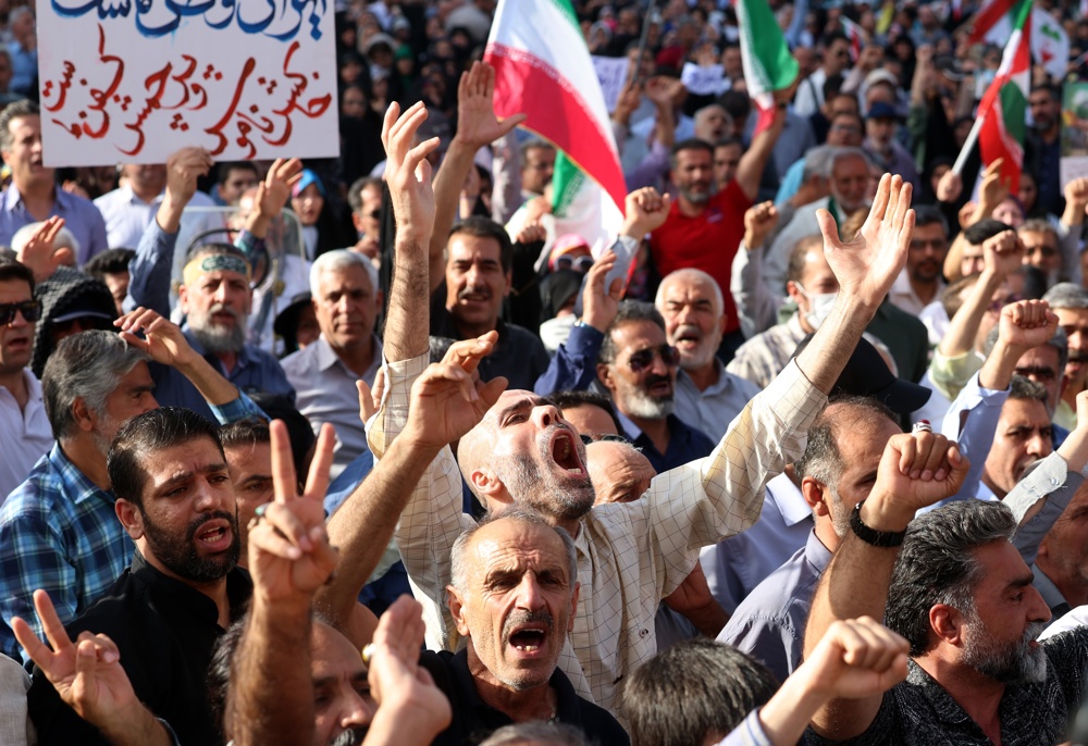 Iranianos gritam palavras de ordem durante manifestação contra os Estados Unidos e Israel, em Teerã