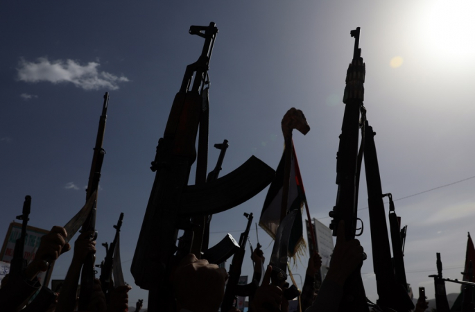 Apoiadores houthis exibem suas armas durante um protesto contra os Estados Unidos e Israel em Sanaá, Iêmen