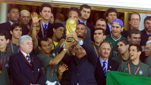 O capitão da Seleção Brasileira, Cafu, e o Presidente do Brasil, Fernando Henrique Cardoso, levantam a taça juntos sob os olhares dos jogadores e da comissão técnica do Brasil, além do presidente da CBF (Confederação Brasileira de Futebol) Ricardo Teixeira