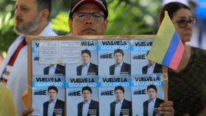Um homem segura um cartaz com propaganda do candidato à presidência Miguel Uribe durante um protesto contra a violência e em defesa da paz, em Medellín, na Colômbia, em 8 de junho de 2025, um dia após o atentado contra Uribe. Um dos principais candidatos da direita colombiana à presidência, que foi baleado durante um evento de campanha em Bogotá, passou com sucesso por uma cirurgia inicial, informou a prefeita da capital neste domingo. O senador Miguel Uribe, de 39 anos, falava com apoiadores quando um atirador o atingiu com dois tiros na cabeça e um no joelho