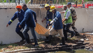 Bombeiros carregam o corpo de uma vítima após a queda do voo 171 da Air India em uma área residencial próxima ao aeroporto de Ahmedabad, em 12 de junho de 2025. O avião de passageiros, que seguia para Londres, caiu na cidade de Ahmedabad, no oeste da Índia, com 242 pessoas a bordo, segundo autoridades da aviação. A companhia aérea classificou o ocorrido como um "acidente trágico". (Foto: Sam Panthaky / AFP)