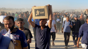 Palestinos deslocados carregam suprimentos de ajuda da Gaza Humanitarian Foundation (GHF), uma organização privada apoiada pelos Estados Unidos que tem contornado o tradicional sistema liderado pela ONU no território, e retornam dos centros de distribuição em Rafah para suas tendas, no sul da Faixa de Gaza, em 29 de maio de 2025. A situação humanitária em Gaza — onde a ajuda começou finalmente a chegar após dois meses de bloqueio — é crítica, após 18 meses de guerra devastadora entre Israel e o movimento palestino Hamas. Especialistas em segurança alimentar alertam que a fome ameaça uma em cada cinco pessoas. (Foto: AFP)