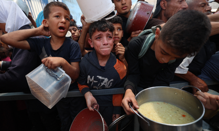 Crianças palestinas aguardam por comida em um ponto de distribuição em Nuseirat, no centro da Faixa de Gaza, em 11 de junho de 2025. Israel tem enfrentado crescente condenação pela crise humanitária na Faixa de Gaza, devastada pela guerra, onde as Nações Unidas alertaram que toda a população corre o risco de fome após a falta de entrada de ajuda por mais de dois meses. (Foto de Eyad BABA / AFP)