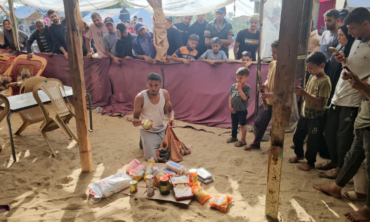 Palestinos deslocados recebem pacotes de alimentos de uma fundação apoiada pelos EUA que se compromete a distribuir ajuda humanitária no oeste de Rafah, no sul da Faixa de Gaza, em 27 de maio de 2025. Milhares de palestinos correram para um novo centro de distribuição de ajuda administrado por um grupo apoiado pelos EUA no sul de Gaza em 27 de maio, relataram jornalistas da AFP, o que provocou cenas caóticas enquanto Israel implementava um novo sistema de distribuição. O incidente em Rafah ocorreu dias após o alívio parcial do bloqueio total de ajuda ao território imposto por Israel em 2 de março, o que levou a uma grave escassez de alimentos e medicamentos. (Foto da AFP)
