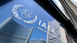 Prédios da sede da Agência Internacional de Energia Atômica (AIEA) refletidos nas portas com o logotipo da agência durante a reunião do Conselho de Governadores da AIEA em Viena, Áustria, em 13 de junho de 2025, onde o chefe da AIEA, Rafael Grossi, informou os membros do conselho sobre os ataques israelenses ao Irã, incluindo à instalação de enriquecimento de urânio de Natanz. (Foto de Joe Klamar / AFP)