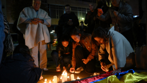 Pessoas acendem velas do lado de fora da Clínica Fundación Santa Fe, onde o senador Miguel Uribe Turbay recebe atendimento médico após ter sido baleado em Bogotá, em 7 de junho de 2025. O senador colombiano de oposição e pré-candidato à presidência nas eleições do próximo ano, Miguel Uribe Turbay, de 39 anos, foi baleado e ferido em Bogotá, segundo diversos meios de comunicação, enquanto o governo classificou o caso como um "atentado". (Foto: Raul Arboleda / AFP)