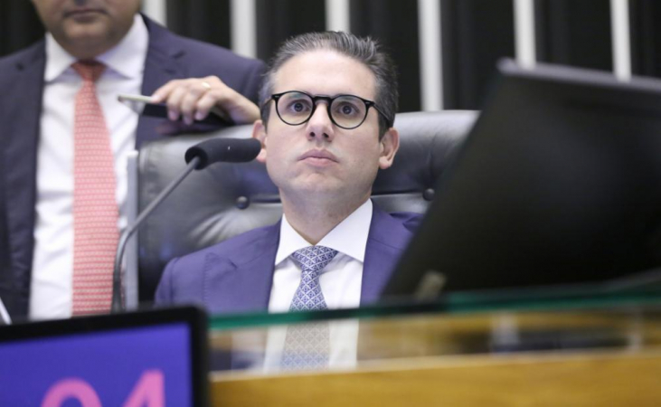 Hugo Motta sentado na cadeira de presidente da Câmara