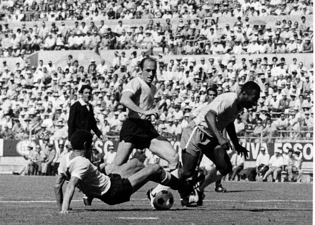 O atacante da Seleção Brasileira, Pelé, disputa bola com jogador da seleção do Urugua