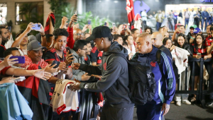 O zagueiro Léo Pereira tira fotos com torcedores na chegada do Flamengo a Santos