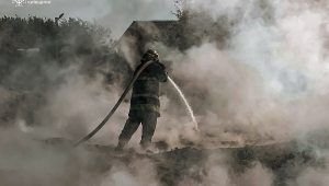 bombeiro apagando um incêndio após um ataque russo na região de Kiev