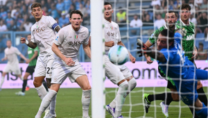 Giovanni Di Lorenzo (#22), e o meio-campista escocês Scott McTominay (#8) observam a bola enquanto o goleiro italiano do Sassuolo, Stefano Turati (#13), não consegue defender o gol marcado pelo meia belga Kevin De Bruyne (#11, fora da imagem)