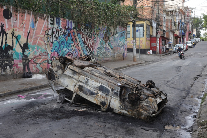 Vista de carro queimado por manifestantes na rua Clementine Brenne, perto de um dos acessos ao bairro de Paraisópolis