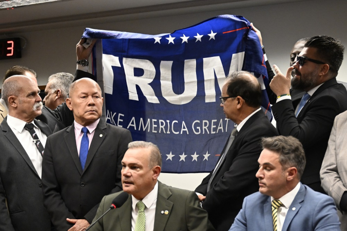 Deputados levantam bandeira em apoio ao presidente norte-americano, Donald Trump, durante reunião comissão de segurança pública e o crime organizado em apoio ao ex-presidente Jair Bolsonaro