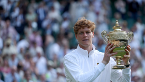 O italiano Jannik Sinner comemora com o troféu após vencer a final de simples masculina contra o espanhol Carlos Alcaraz no torneio de Wimbledon