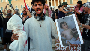 Manifestantes seguram fotos de crianças famintas de Gaza durante um protesto pró-Palestina em Atenas