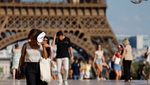 Uma turista usa um chapéu para se proteger do sol durante uma onda de calor na praça Trocadero, perto da Torre Eiffel, em Paris, em 30 de junho de 2025. As autoridades francesas colocaram Paris em alerta vermelho devido ao calor extremo, e Espanha e Portugal registraram temperaturas recordes enquanto uma onda de calor assolava o sul da Europa e a Grã-Bretanha em 30 de junho de 2025, disparando alertas de saúde e alimentando incêndios florestais. (Foto de Ludovic MARIN / AFP)