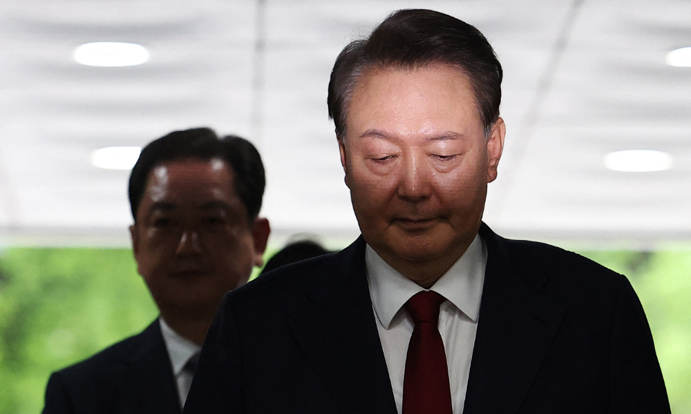 O ex-presidente da Coreia do Sul, Yoon Suk Yeol (à direita), após ser acusado, chega a um tribunal para participar de uma audiência de revisão do seu mandado de prisão solicitado por promotores especiais em Seul, em 9 de julho de 2025. Os promotores sul-coreanos solicitaram um novo mandado de prisão em 6 de julho para deter o ex-presidente Yoon Suk Yeol, após interrogá-lo duas vezes, incluindo uma sessão que durou mais de nove horas. (Foto de KIM HONG-JI / POOL / AFP)