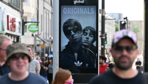 Um anúncio da banda de rock britânica Oasis é visto no centro de Cardiff em 4 de julho de 2025, antes do show de abertura de sua aguardada turnê de reunião, quase 16 anos após a última apresentação. Duas noites consecutivas de shows no Principality Stadium, na capital galesa, marcam o início de uma série de 41 datas de shows espalhados pelo mundo. (Foto de Oli SCARFF / AFP)