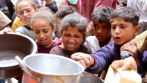 Crianças palestinas fazem fila para uma refeição quente em uma cozinha beneficente na Cidade de Gaza, em 30 de abril de 2025. A agência de alimentos da ONU, uma das principais fornecedoras de assistência alimentar no território palestino sitiado, informou em 25 de abril que havia "entregado seus últimos estoques de alimentos para cozinhas de refeições quentes na Faixa de Gaza", onde Israel bloqueou toda a ajuda por mais de sete semanas, acrescentando que "essas cozinhas devem ficar sem comida nos próximos dias". (Foto de Omar AL-QATTAA / AFP)